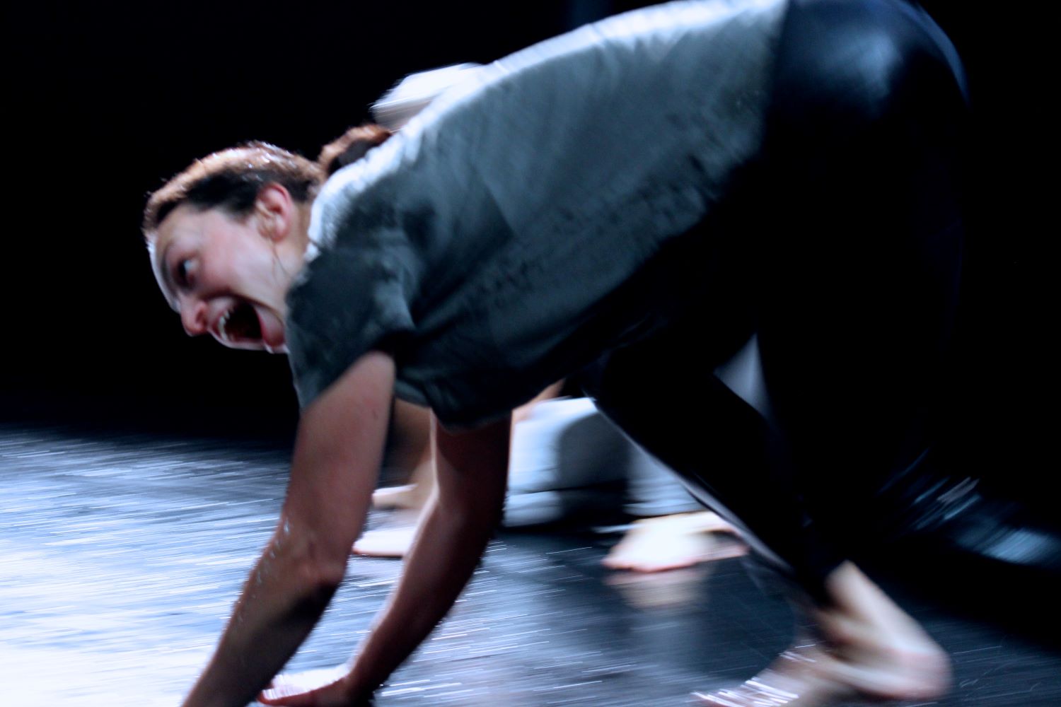 A woman moving in medium level sliding on a wet floor with her hands and feet
