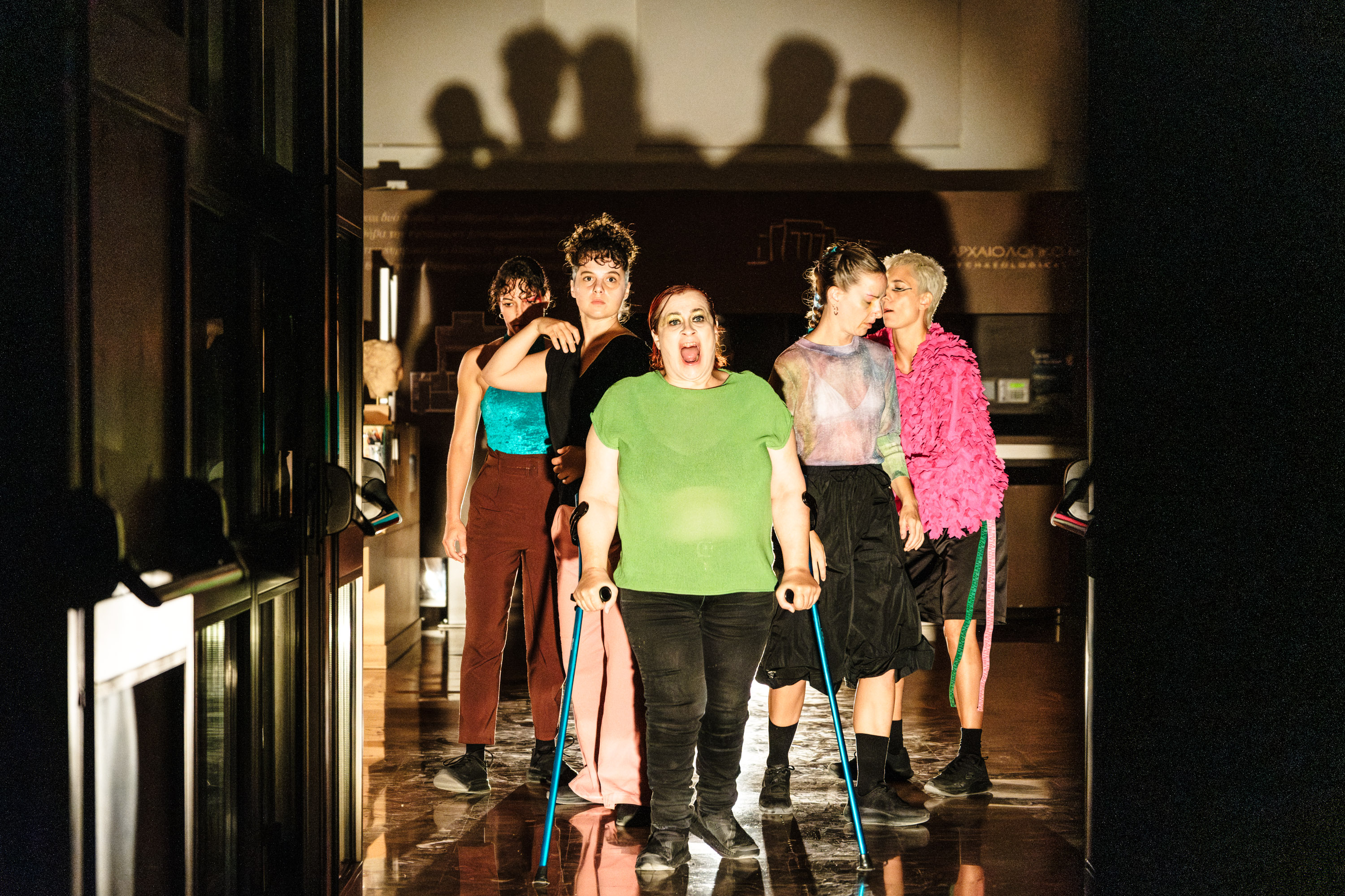 Πέντε γυναίκες ντυμένες με ζωηρά χρώματα περπατούν προς το μέρος μας. Την πορεία οδηγεί η Ντέμη, ανάπηρη χορεύτρια, η οποία χρησιμοποιεί τις πατερίτσες της.