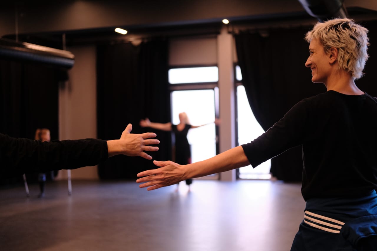 in a studio space, two hands reaching for each other 