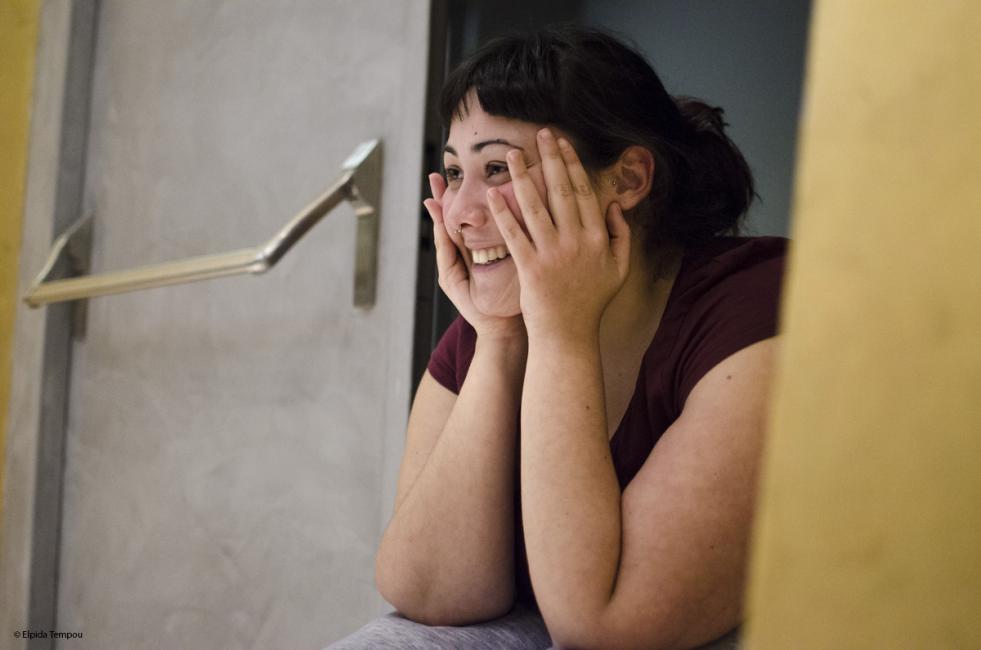 a dancer sitting holds her face with her two hands full of joy